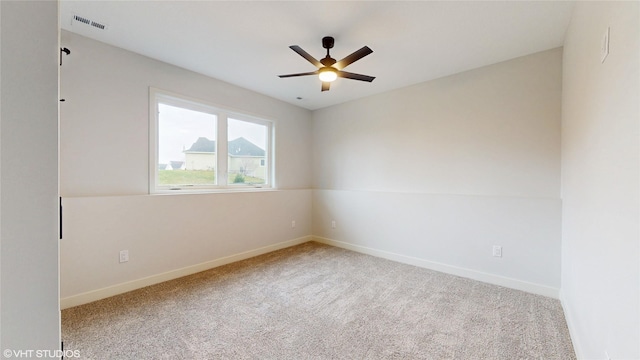 carpeted empty room featuring baseboards, visible vents, and a ceiling fan