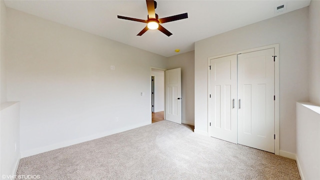 unfurnished bedroom featuring baseboards, ceiling fan, a closet, and carpet floors