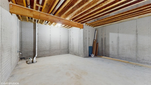 unfinished below grade area featuring brick wall