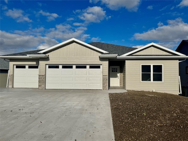 202 Meadowlark Dr, Monroe, IA 50170 - ranch-style house featuring an attached garage, concrete driveway, and stone siding