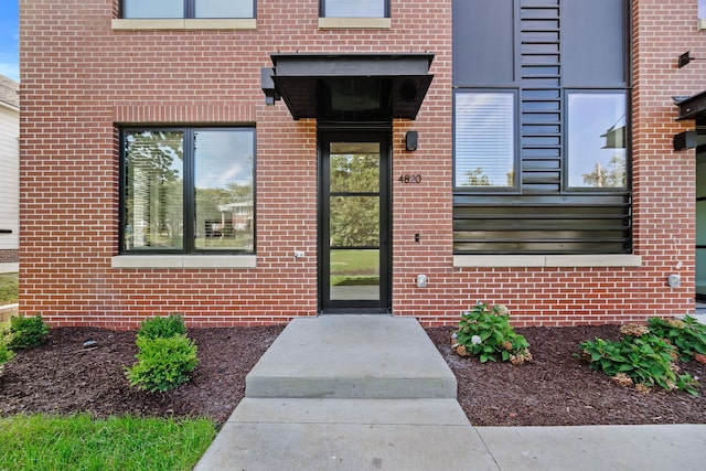 view of exterior entry with brick siding