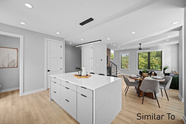 4828 Ingersoll Ave, Des Moines, IA 50312 - kitchen with pendant lighting, modern cabinets, light wood-style floors, and a center island