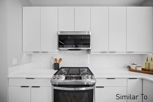 4828 Ingersoll Ave, Des Moines, IA 50312 - kitchen with decorative backsplash, light countertops, white cabinets, and stainless steel appliances