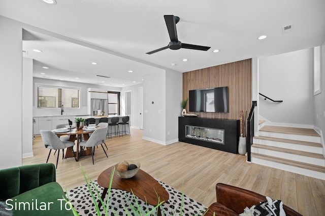 4828 Ingersoll Ave, Des Moines, IA 50312 - living area with baseboards, stairway, light wood-type flooring, recessed lighting, and a glass covered fireplace
