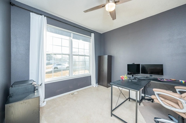 office featuring light carpet, visible vents, ceiling fan, and baseboards