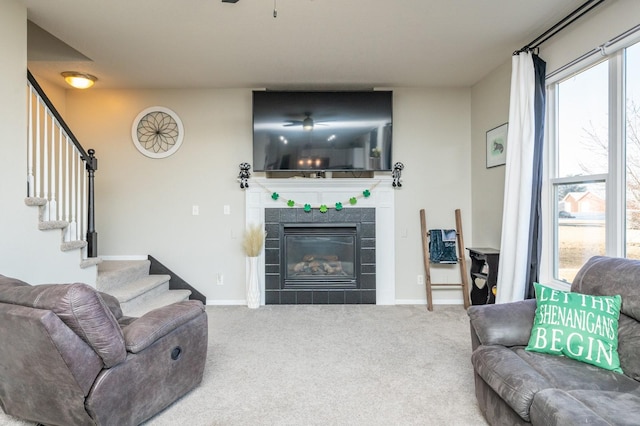 living room with stairs, baseboards, carpet, and a fireplace