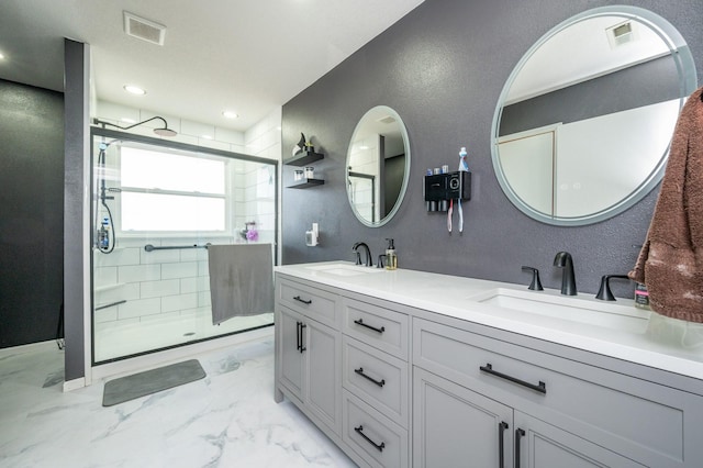 bathroom with a stall shower, visible vents, marble finish floor, and a sink