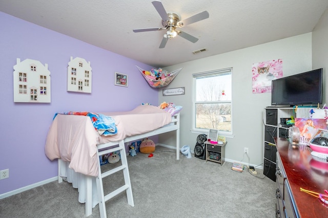 carpeted bedroom with visible vents, a textured ceiling, baseboards, and ceiling fan