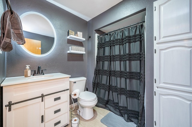 bathroom with a shower with curtain, toilet, vanity, and a textured wall