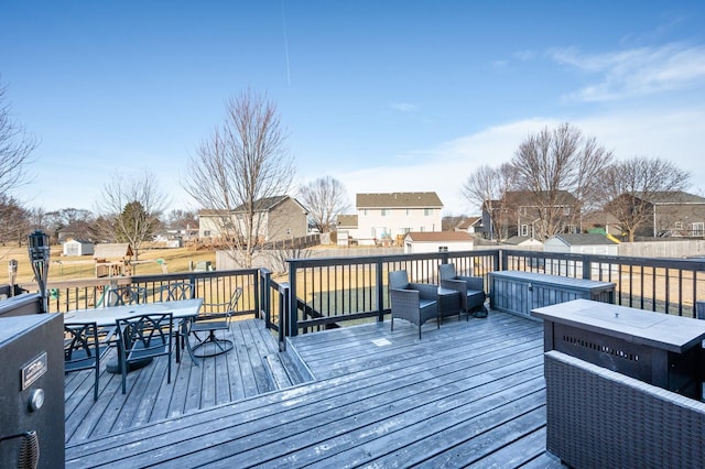 deck featuring outdoor dining area, a residential view, and fence