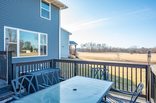 wooden terrace featuring outdoor dining area and a yard