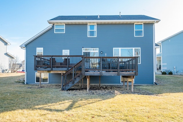 back of property with a deck, a yard, and stairs