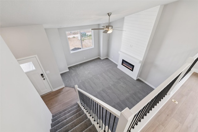 2917 Jerry St, Van Meter, IA 50261 - stairway with a glass covered fireplace, ceiling fan, and wood finished floors