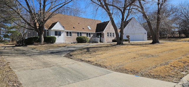 view of front of home with driveway, brick siding, and an attached garage