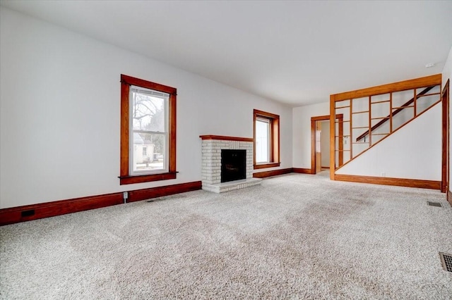 unfurnished living room featuring visible vents, a fireplace, baseboards, and carpet floors