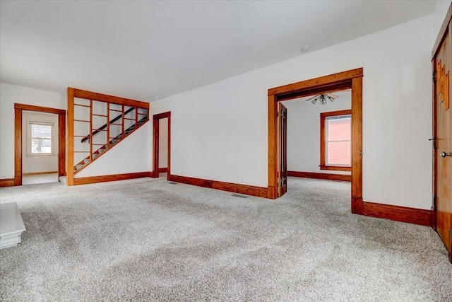 empty room with stairway, carpet, and baseboards