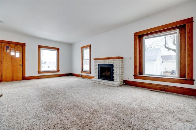 unfurnished living room featuring a fireplace, baseboards, and carpet floors