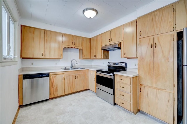 kitchen with light brown cabinets, under cabinet range hood, a sink, appliances with stainless steel finishes, and light countertops