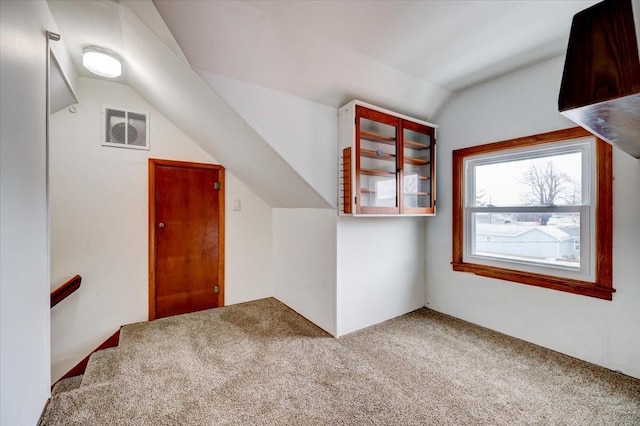 bonus room with visible vents, carpet flooring, and vaulted ceiling