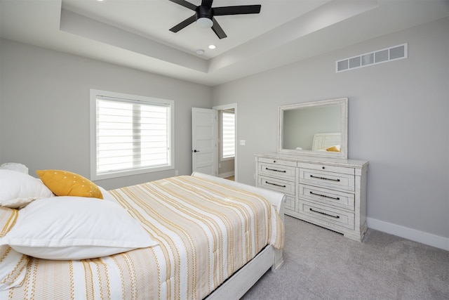 bedroom with visible vents, recessed lighting, baseboards, a raised ceiling, and light colored carpet