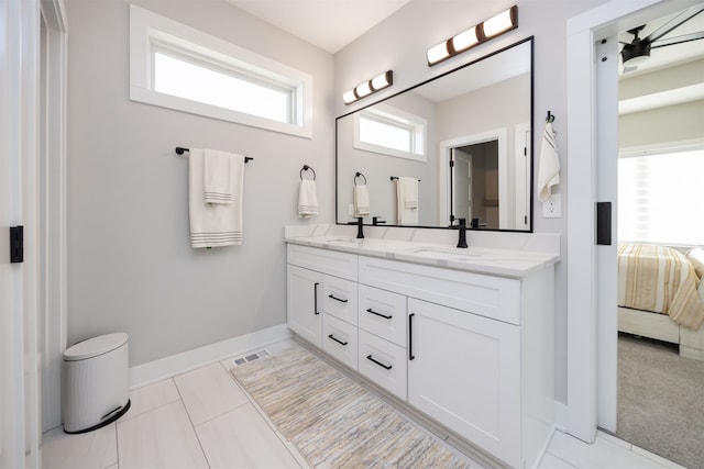 ensuite bathroom featuring visible vents, baseboards, double vanity, ensuite bathroom, and a sink