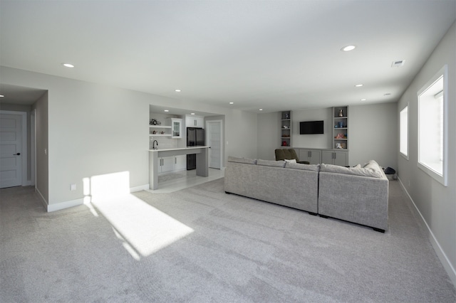 living room featuring light carpet, visible vents, recessed lighting, and baseboards