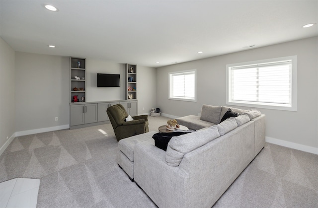 living room featuring recessed lighting, baseboards, and light carpet