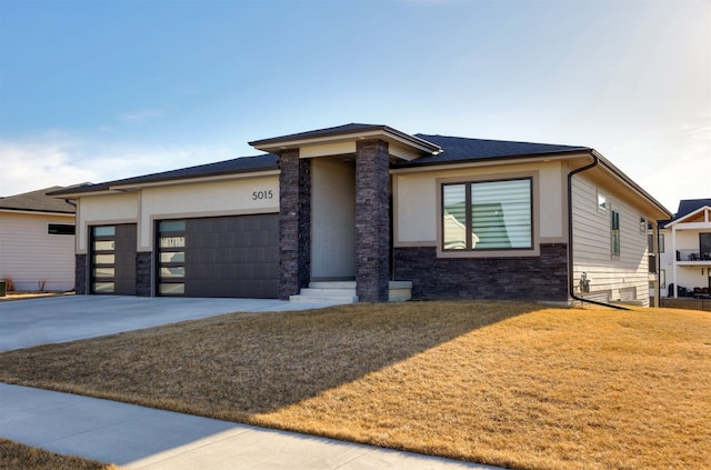 prairie-style home featuring driveway, an attached garage, stucco siding, a front lawn, and stone siding