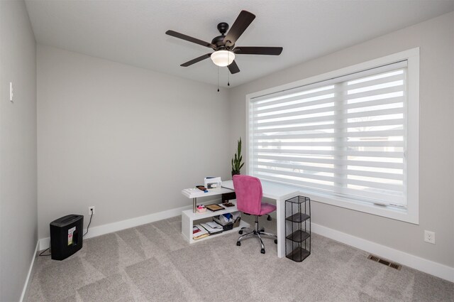 carpeted office space featuring visible vents, ceiling fan, and baseboards