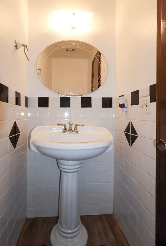 bathroom featuring tile walls, wainscoting, and wood finished floors