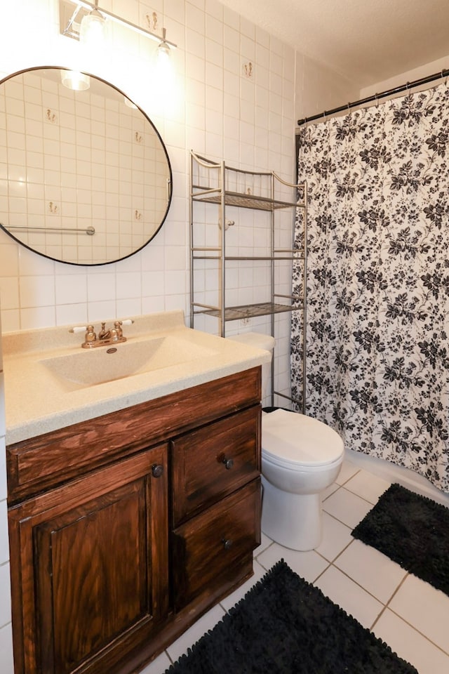 bathroom with vanity, toilet, tile patterned floors, tile walls, and a shower with curtain