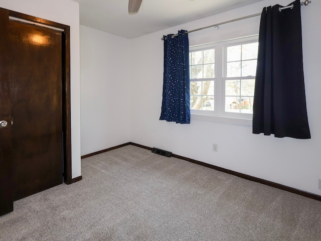 unfurnished bedroom with carpet flooring, a ceiling fan, and baseboards