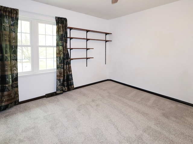 unfurnished room featuring carpet floors, baseboards, and ceiling fan