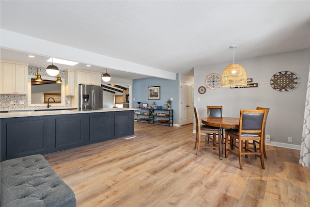 dining room featuring recessed lighting, light wood-style floors, and baseboards