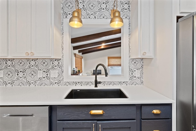 kitchen featuring a sink, stainless steel appliances, white cabinets, and light countertops