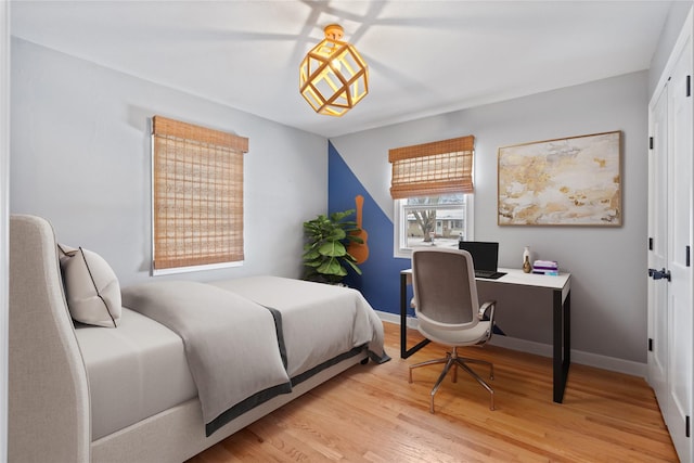 bedroom featuring baseboards and wood finished floors