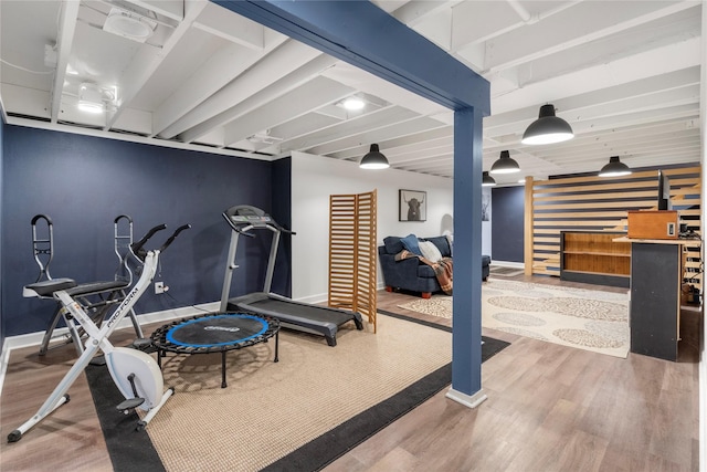 exercise area with baseboards and wood finished floors