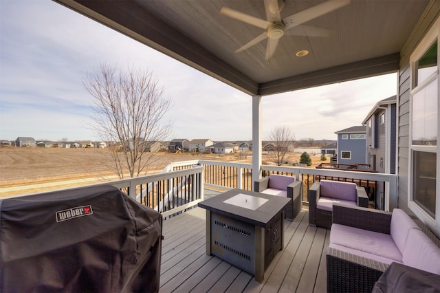 wooden terrace featuring grilling area, a residential view, a ceiling fan, and outdoor lounge area