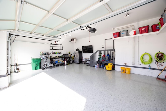 garage with a garage door opener and a wall mounted AC