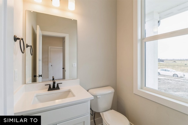 half bathroom featuring toilet and vanity