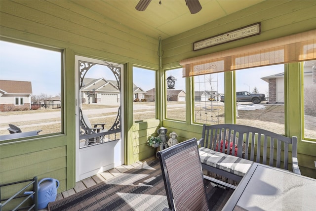 sunroom with a residential view, a wealth of natural light, and ceiling fan