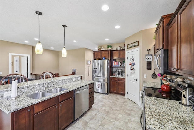 kitchen featuring a sink, stainless steel appliances, decorative light fixtures, and recessed lighting