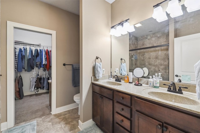 full bath featuring a shower stall, a spacious closet, double vanity, and a sink