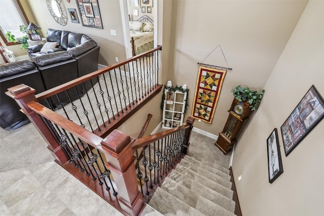 staircase featuring carpet and baseboards