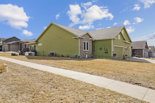 view of home's exterior featuring central air condition unit, a residential view, concrete driveway, a garage, and brick siding