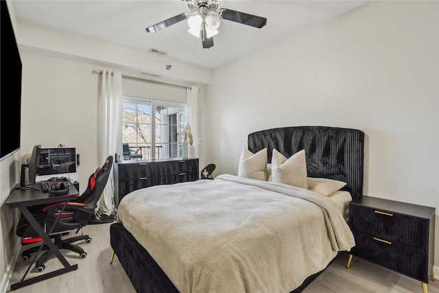 bedroom featuring visible vents, light wood-style floors, and a ceiling fan