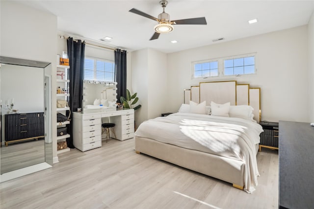 bedroom with visible vents, multiple windows, wood finished floors, and a ceiling fan