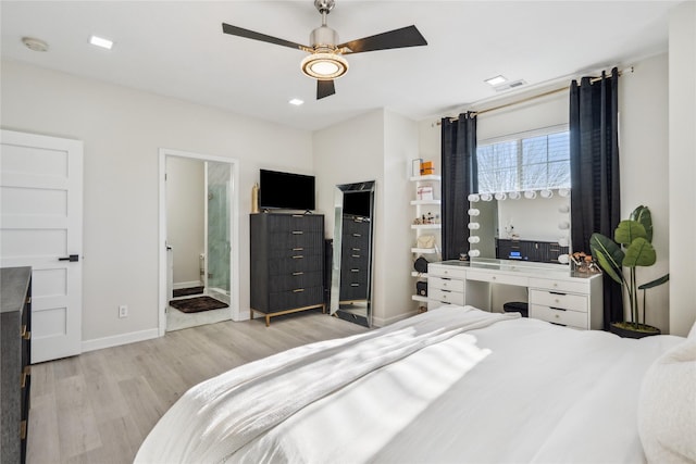 bedroom with visible vents, connected bathroom, ceiling fan, baseboards, and wood finished floors