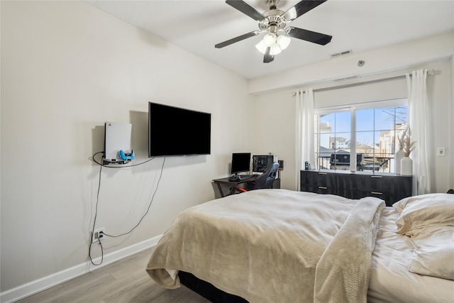 bedroom featuring ceiling fan, visible vents, baseboards, and wood finished floors