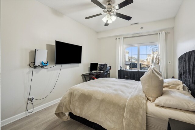 bedroom featuring visible vents, access to outside, wood finished floors, baseboards, and ceiling fan